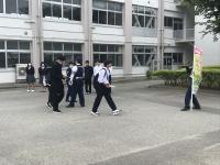 登校してくる生徒に交通安全啓発グッズが手渡されます