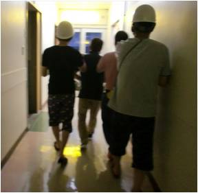 鍵のかかる場所へと避難する舎生たちと手引きで誘導する指導員