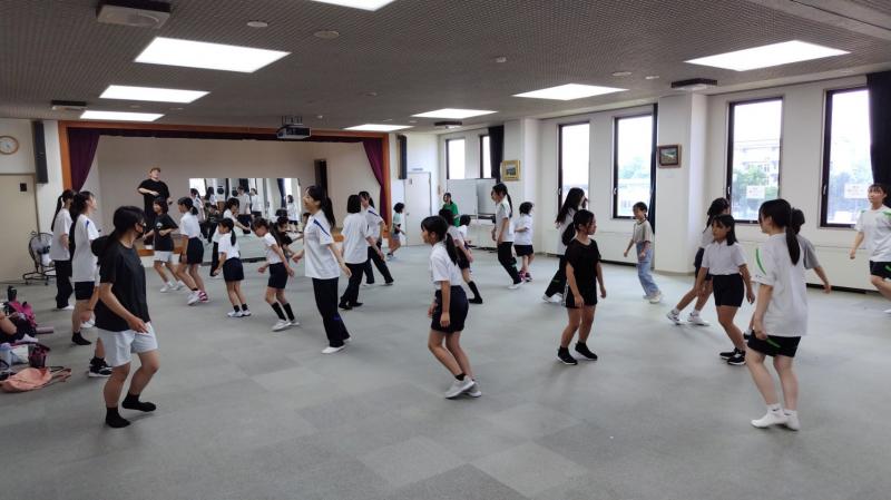 子どもたちとダンスを踊る部員たち